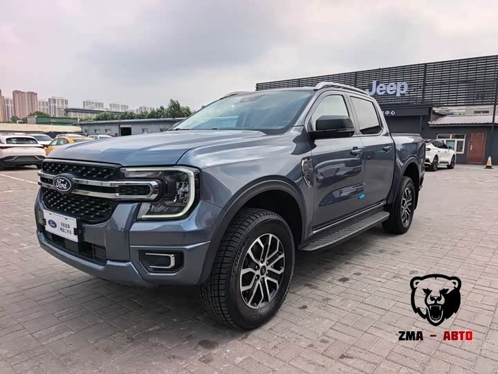 серо-синий Ford Ranger, вид спереди-сбоку на стоянке, вдали вывеска Jeep-дилера